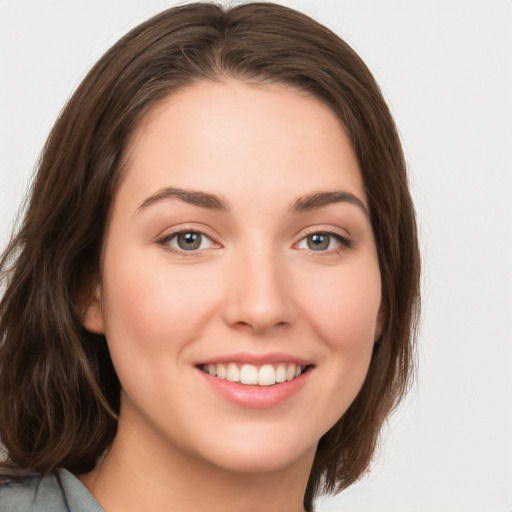 Joyful white young-adult female with long  brown hair and green eyes