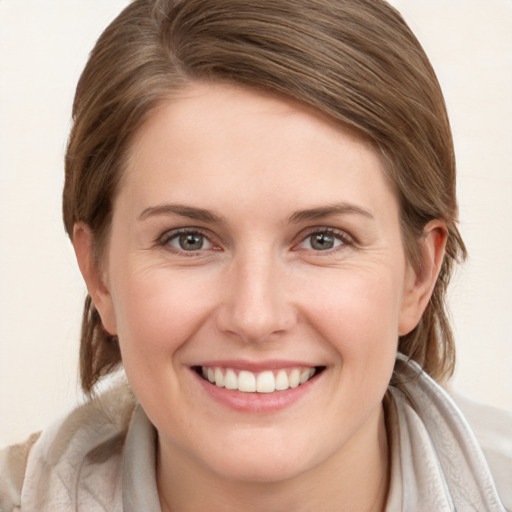 Joyful white young-adult female with medium  brown hair and grey eyes