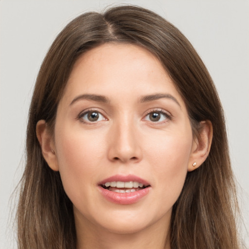 Joyful white young-adult female with long  brown hair and grey eyes