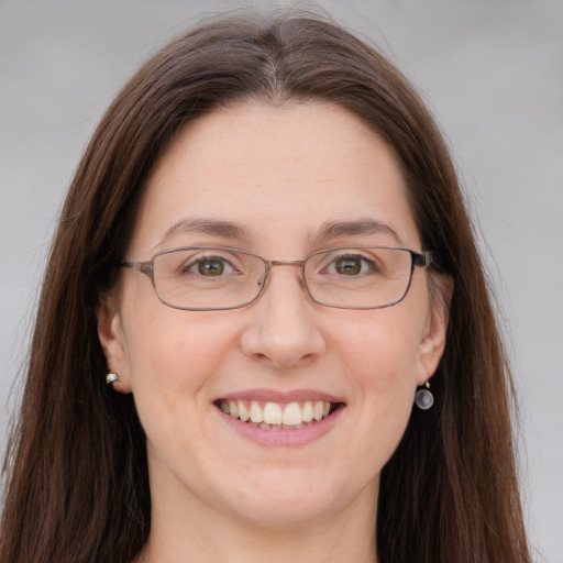 Joyful white adult female with long  brown hair and grey eyes