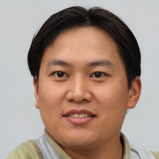 Joyful asian young-adult male with short  brown hair and brown eyes