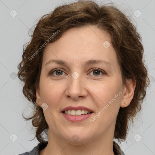 Joyful white adult female with medium  brown hair and green eyes