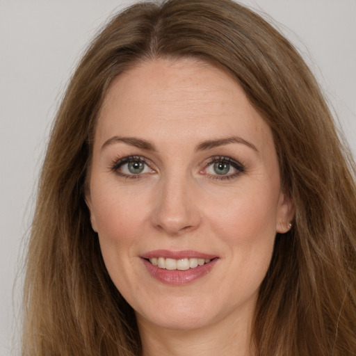 Joyful white adult female with long  brown hair and brown eyes