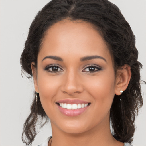 Joyful latino young-adult female with long  brown hair and brown eyes