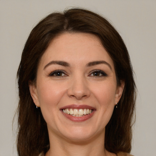 Joyful white young-adult female with long  brown hair and brown eyes