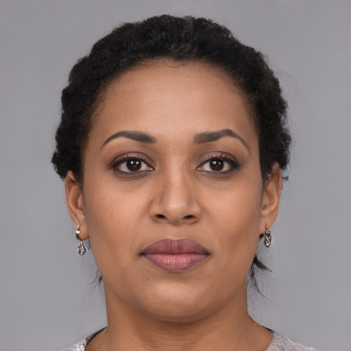 Joyful black adult female with short  brown hair and brown eyes