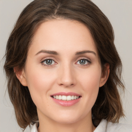 Joyful white young-adult female with medium  brown hair and green eyes