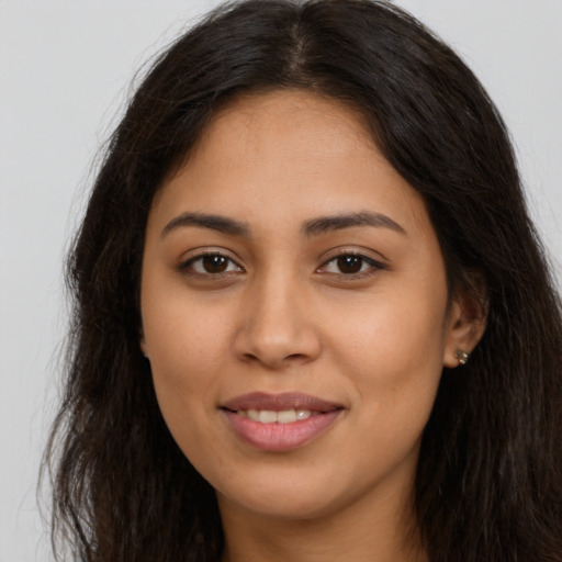 Joyful latino young-adult female with long  brown hair and brown eyes