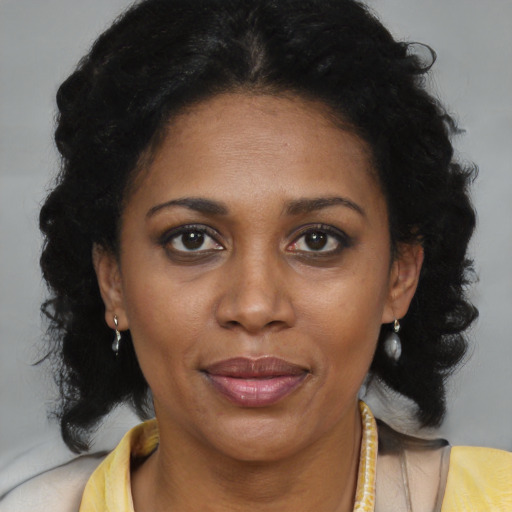 Joyful black adult female with medium  brown hair and brown eyes