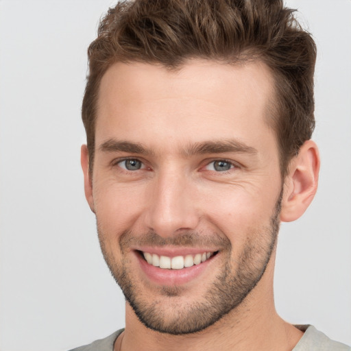 Joyful white young-adult male with short  brown hair and grey eyes