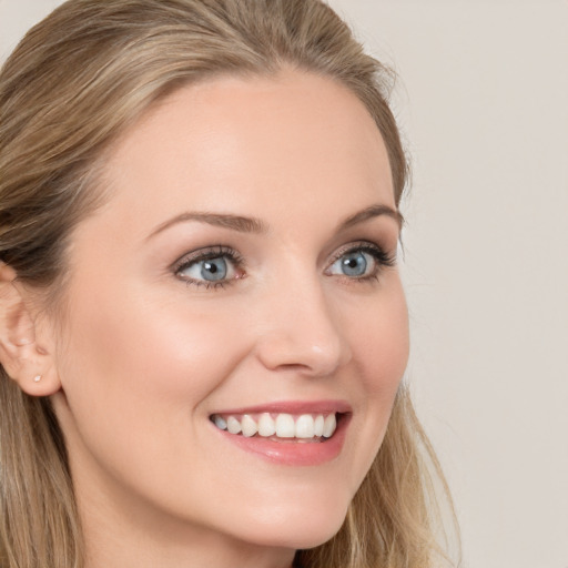 Joyful white young-adult female with long  brown hair and blue eyes