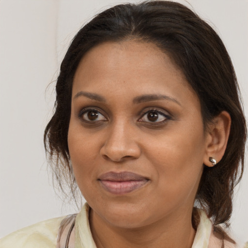 Joyful black adult female with medium  brown hair and brown eyes