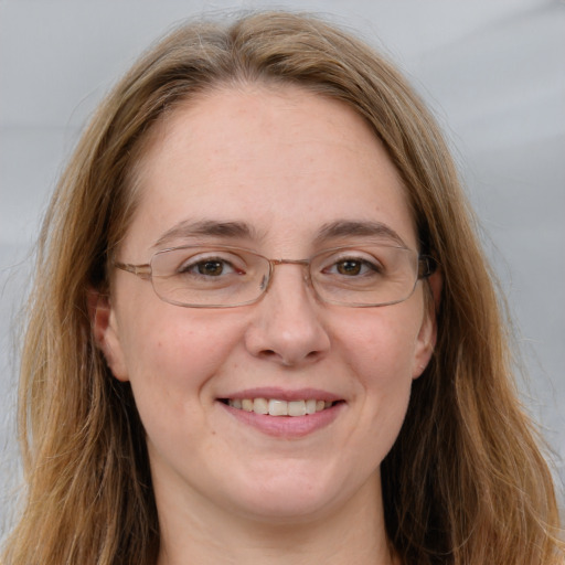 Joyful white adult female with long  brown hair and blue eyes