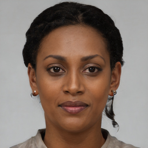 Joyful black young-adult female with short  black hair and brown eyes