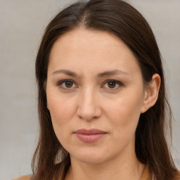 Joyful white adult female with long  brown hair and brown eyes