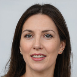 Joyful white adult female with long  brown hair and brown eyes