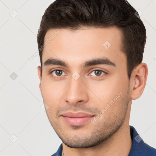 Joyful white young-adult male with short  brown hair and brown eyes