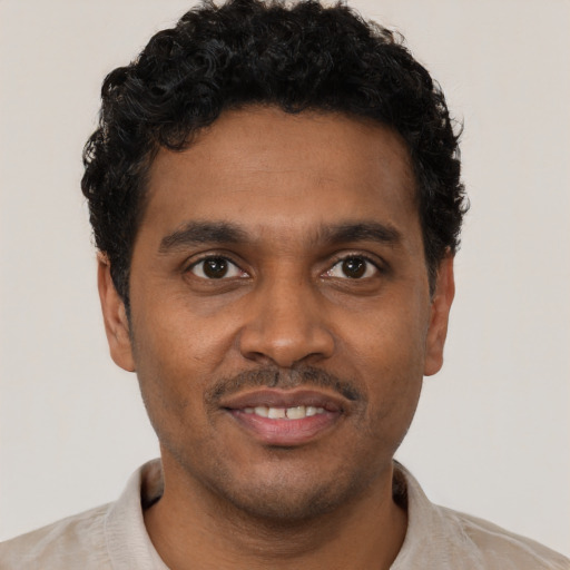 Joyful black young-adult male with short  black hair and brown eyes