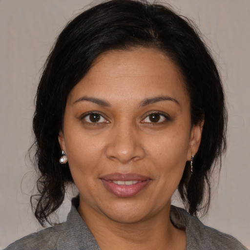 Joyful black adult female with medium  brown hair and brown eyes