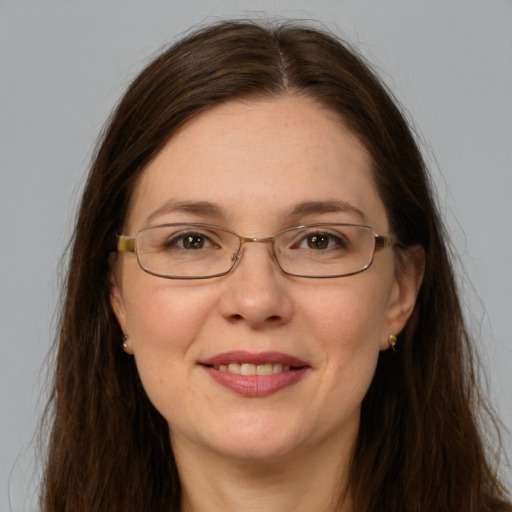 Joyful white adult female with long  brown hair and grey eyes