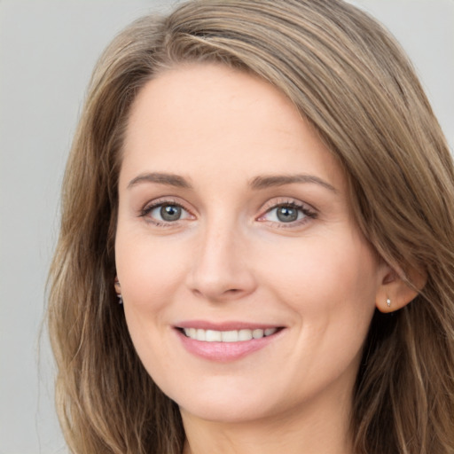 Joyful white young-adult female with long  brown hair and green eyes