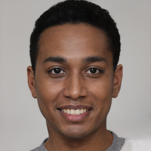 Joyful black young-adult male with short  black hair and brown eyes