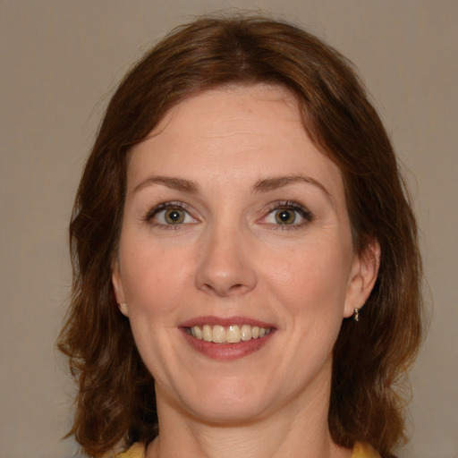 Joyful white young-adult female with medium  brown hair and green eyes