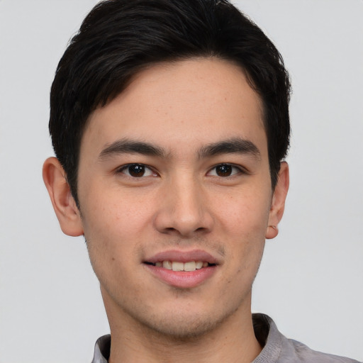 Joyful asian young-adult male with short  brown hair and brown eyes