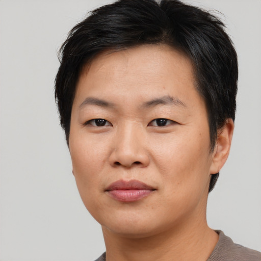 Joyful asian young-adult female with short  brown hair and brown eyes