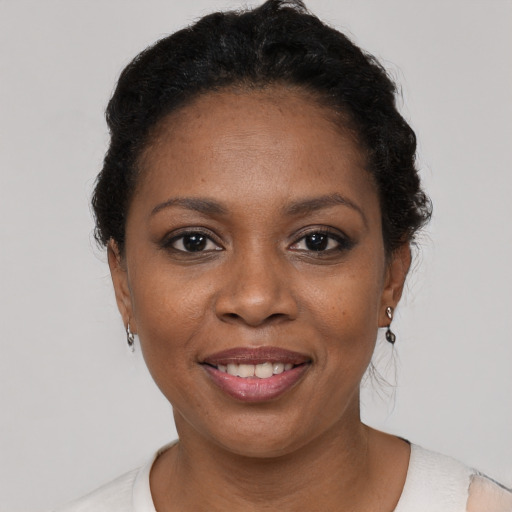 Joyful black young-adult female with short  black hair and brown eyes