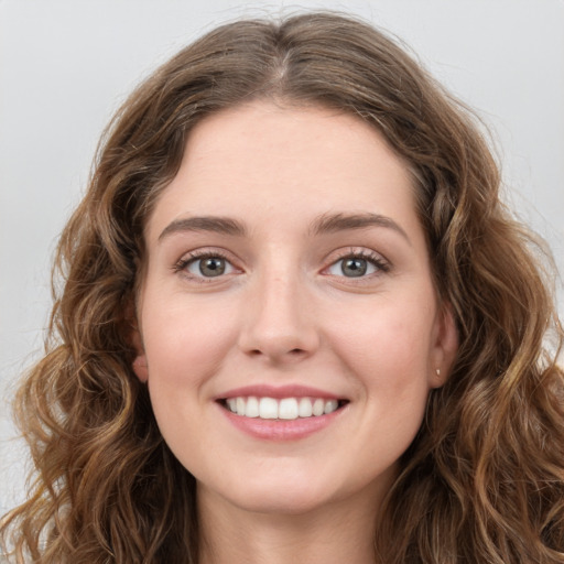 Joyful white young-adult female with long  brown hair and green eyes