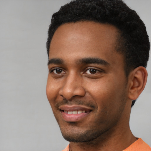 Joyful black young-adult male with short  black hair and brown eyes