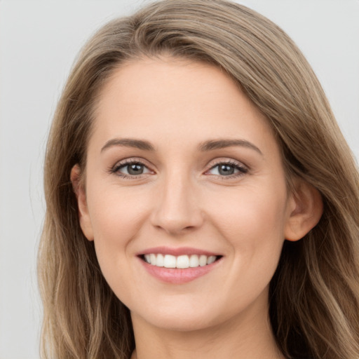 Joyful white young-adult female with long  brown hair and grey eyes