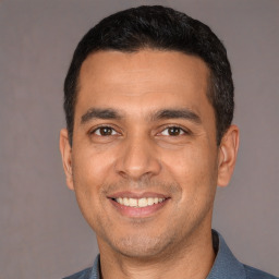 Joyful white young-adult male with short  black hair and brown eyes