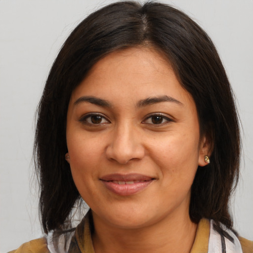 Joyful latino young-adult female with medium  brown hair and brown eyes