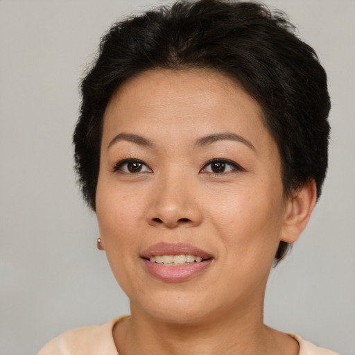 Joyful asian adult female with short  brown hair and brown eyes