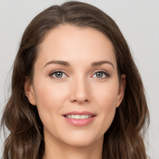 Joyful white young-adult female with long  brown hair and grey eyes