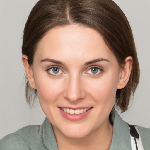 Joyful white young-adult female with medium  brown hair and grey eyes