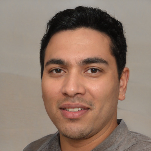 Joyful white young-adult male with short  black hair and brown eyes