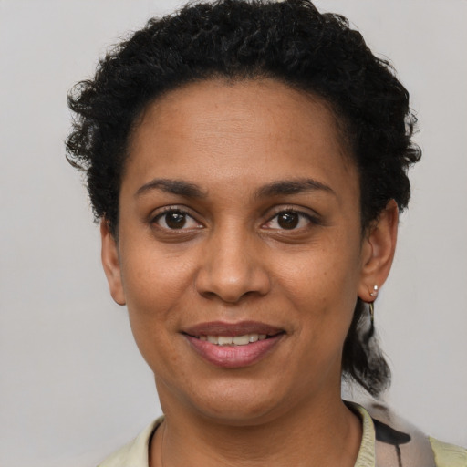 Joyful black adult female with short  black hair and brown eyes