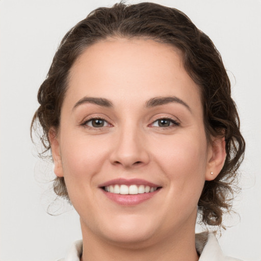 Joyful white young-adult female with medium  brown hair and grey eyes