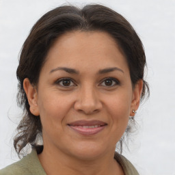 Joyful latino adult female with medium  brown hair and brown eyes