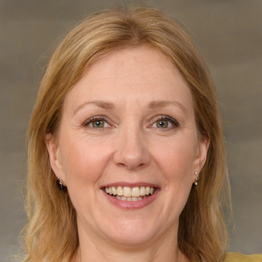 Joyful white adult female with medium  brown hair and green eyes