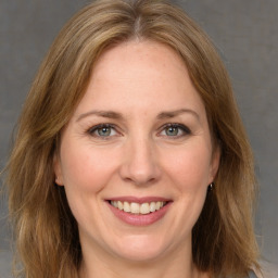 Joyful white adult female with medium  brown hair and grey eyes