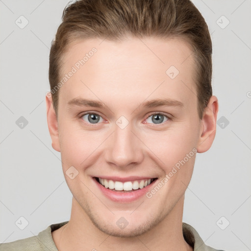 Joyful white young-adult male with short  brown hair and grey eyes