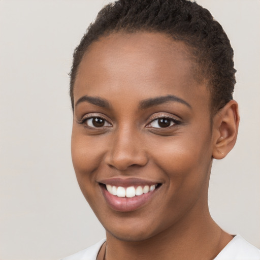 Joyful black young-adult female with short  brown hair and brown eyes