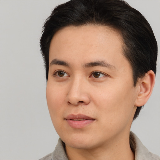 Joyful asian young-adult male with short  brown hair and brown eyes