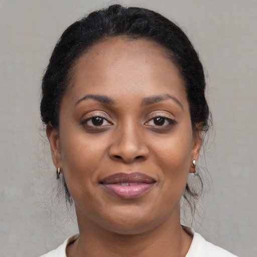 Joyful black young-adult female with long  brown hair and brown eyes