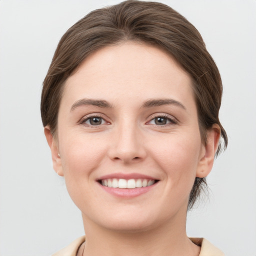 Joyful white young-adult female with short  brown hair and grey eyes