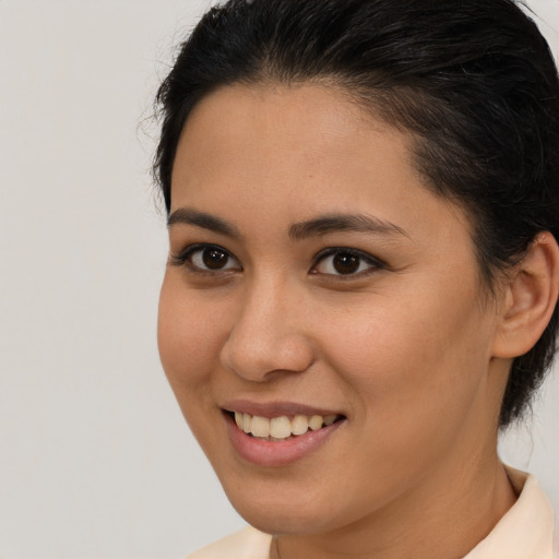 Joyful latino young-adult female with medium  brown hair and brown eyes